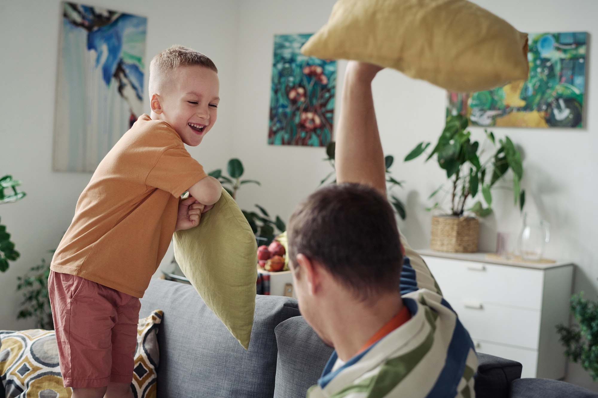 Son playing pillow fight with dad